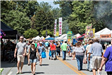 Crowd of People Walking Among Festival Tents