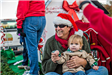 Man Wearing a Santa Hat Holding Child