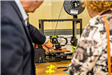 People Examining 3D Printer