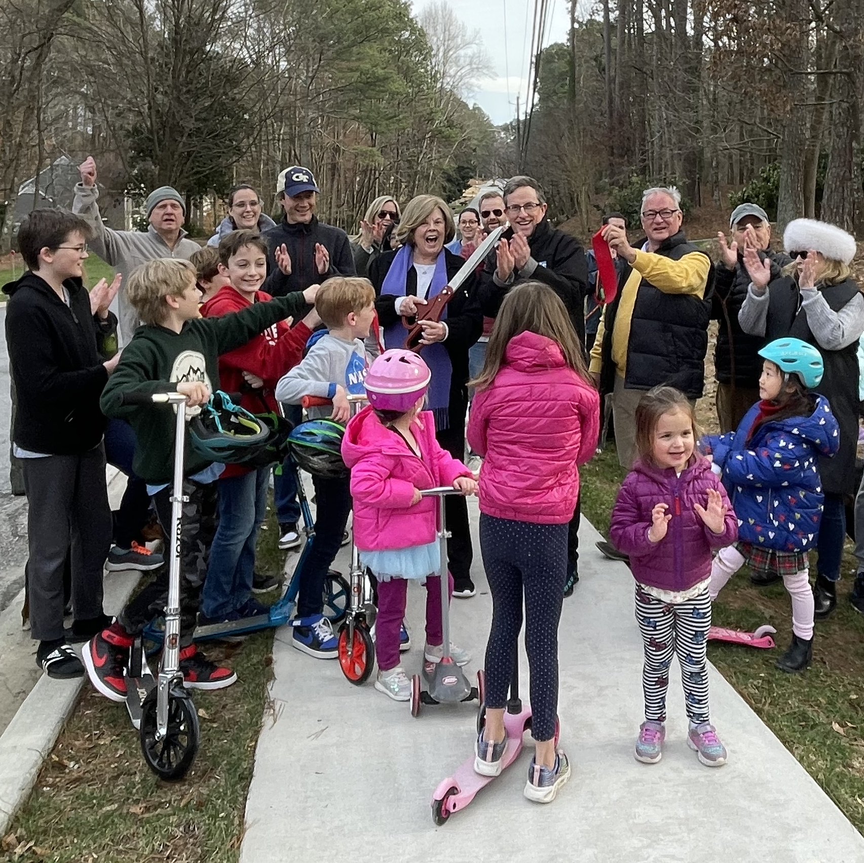 Group of People Cutting Ribbon for Sidewalk Opening