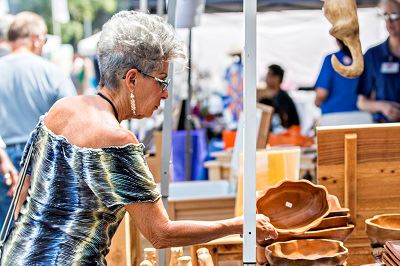 Woman Inspecting Wooden Bowl