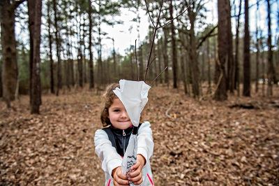 Child Holding a Seedling Tree in a Bag