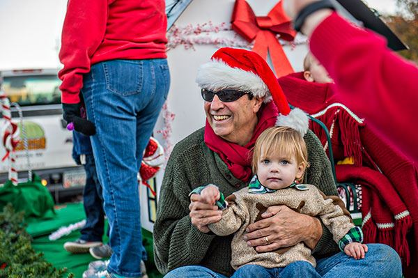 Man Wearing a Santa Hat Holding Child