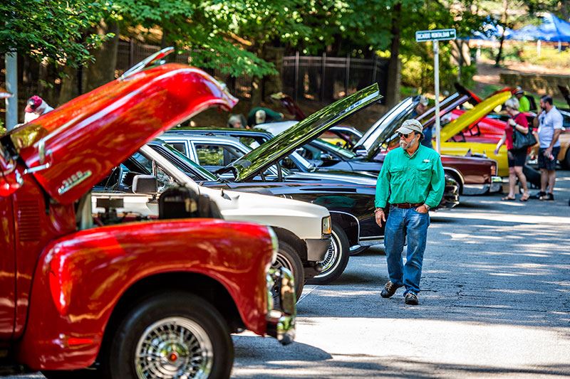 Man Walking and Looking at Classic Cars