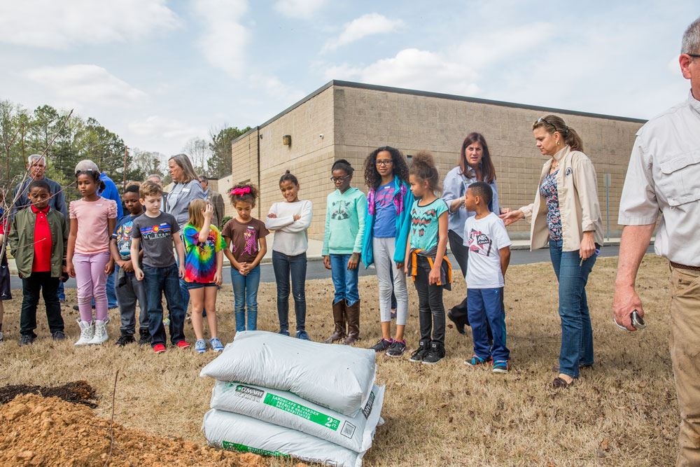 Children Standing with Bags of Soil