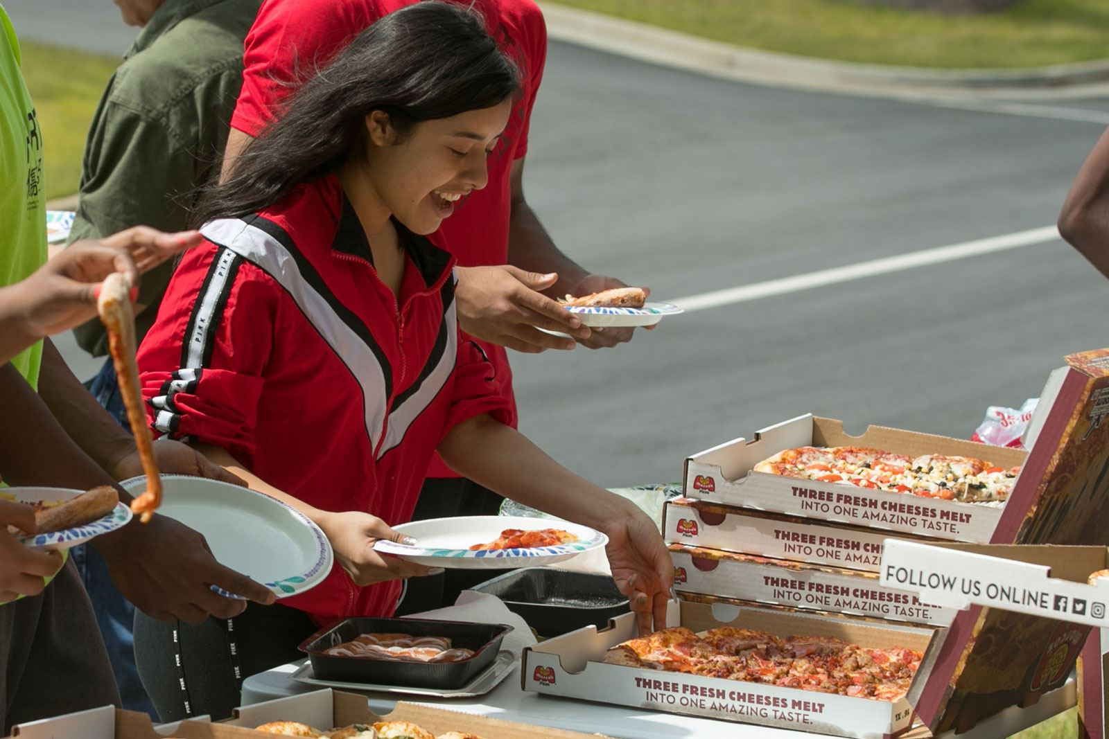 People Getting Slices of Pizza