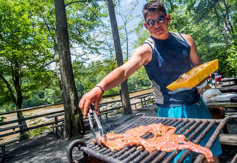 A man grilling meat at Jones Bridge Park